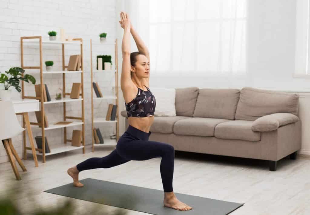 Mujer atlética haciendo yoga, ejercicio de estiramiento en casa