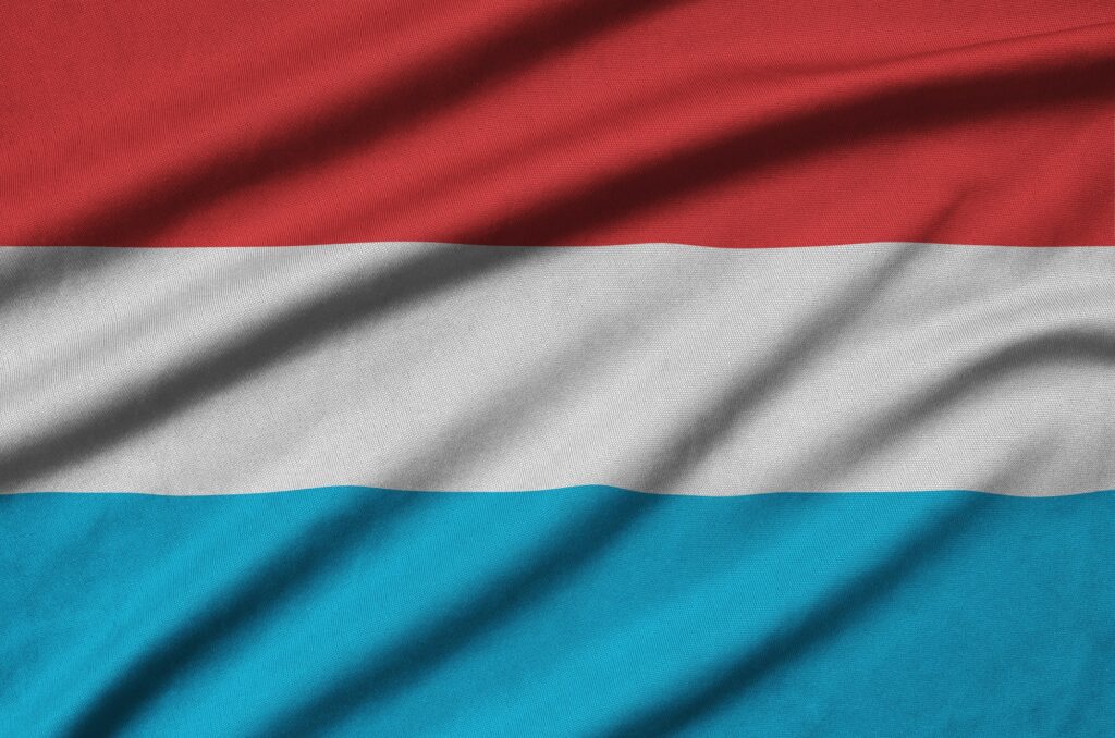La bandiera del Lussemburgo è raffigurata su un tessuto sportivo con molte pieghe. Squadra sportiva che sventola lo striscione