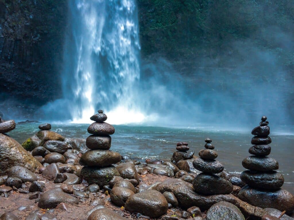 Pierres empilées pour la méditation devant une cascade bleue dans la jungle