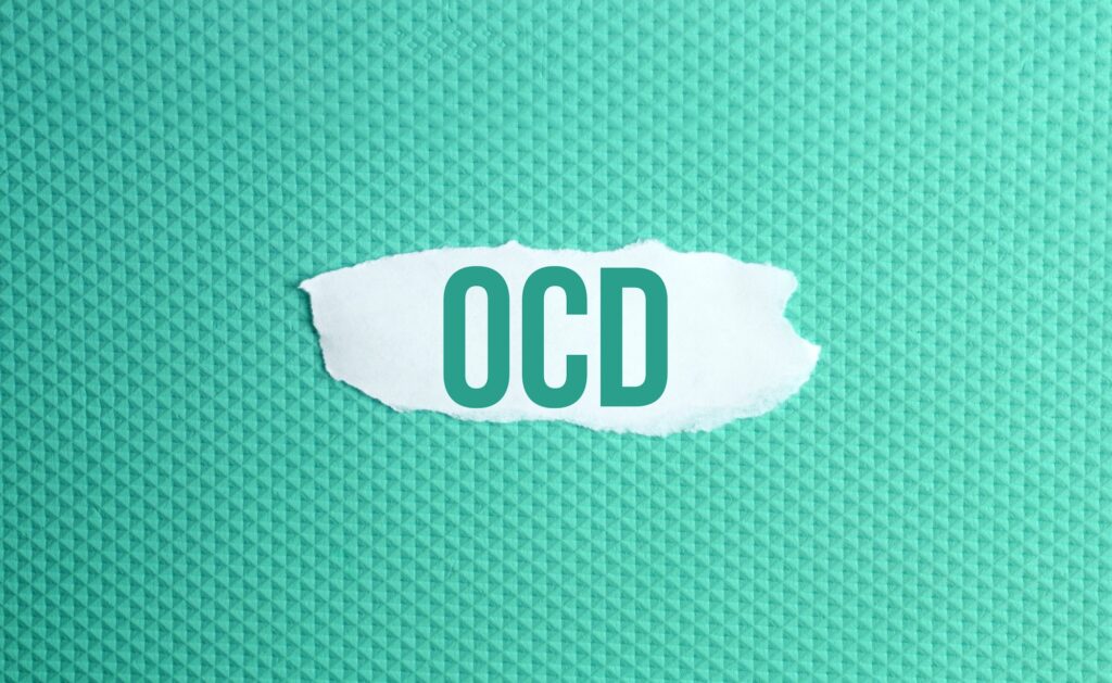 Trastorno obsesivo-compulsivo. un papel rasgado con la inscripción OCD sobre fondo verde