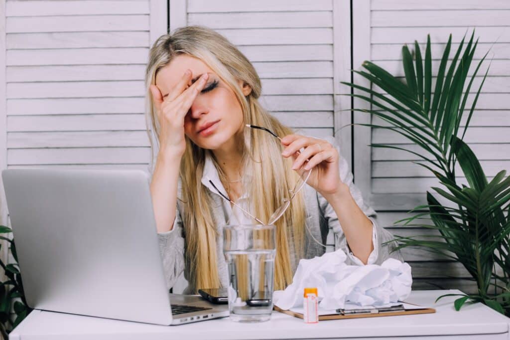 Femme d'affaires stressée travaillant à domicile sur son ordinateur portable et ayant un mal de tête