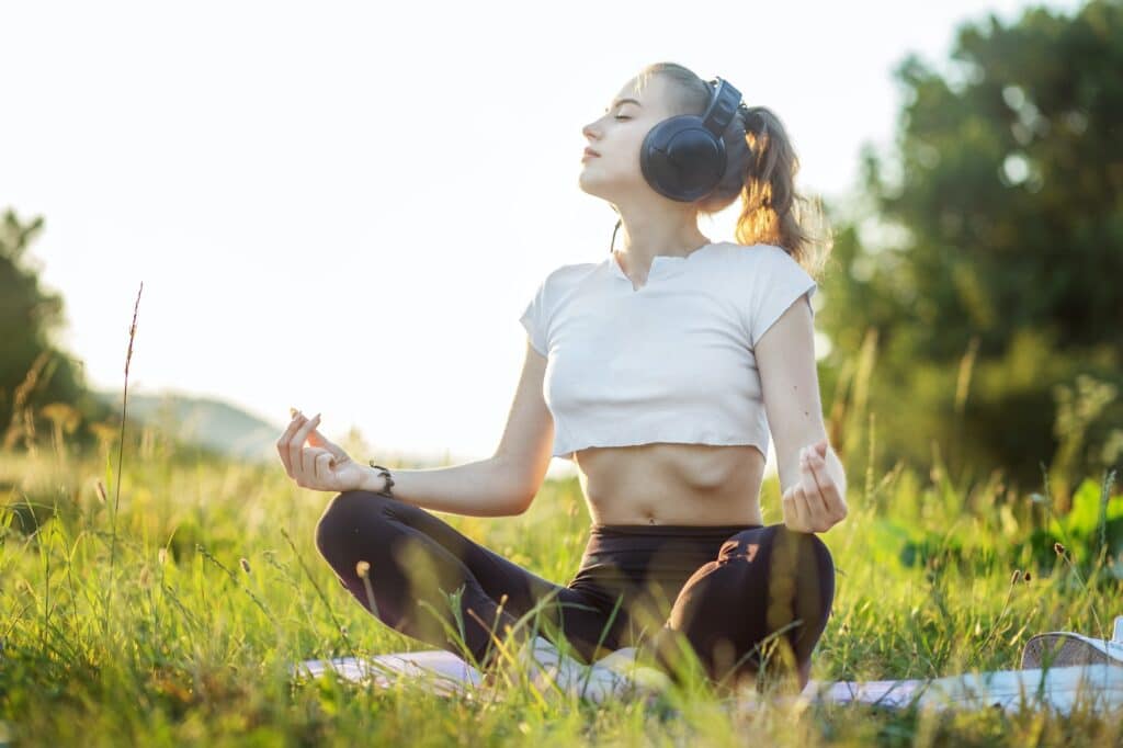 The girl listens to music on headphones. A woman is meditating. Concept for lifestyle, music